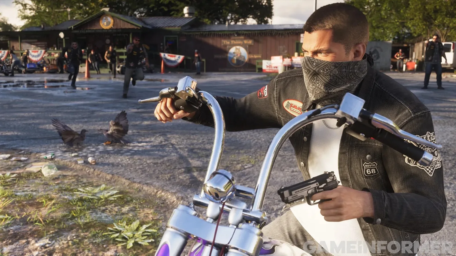 Jason à moto, bandana sur le visage, devant un rassemblement de bikers
