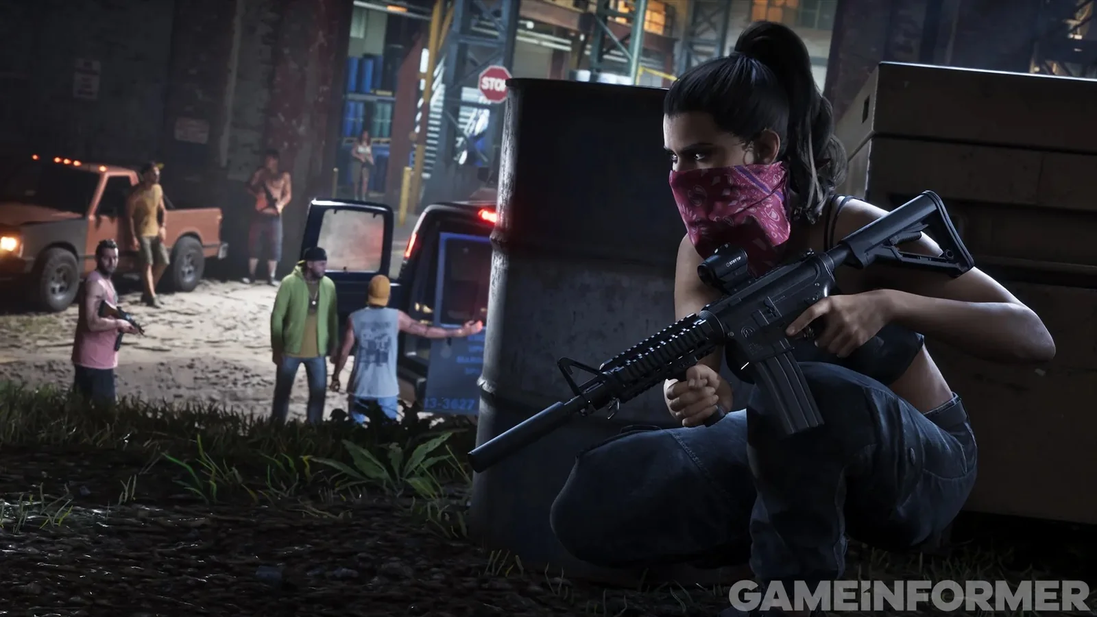 Lucia accroupie derrière un bidon, fusil d'assaut en main, bandana rose sur le visage